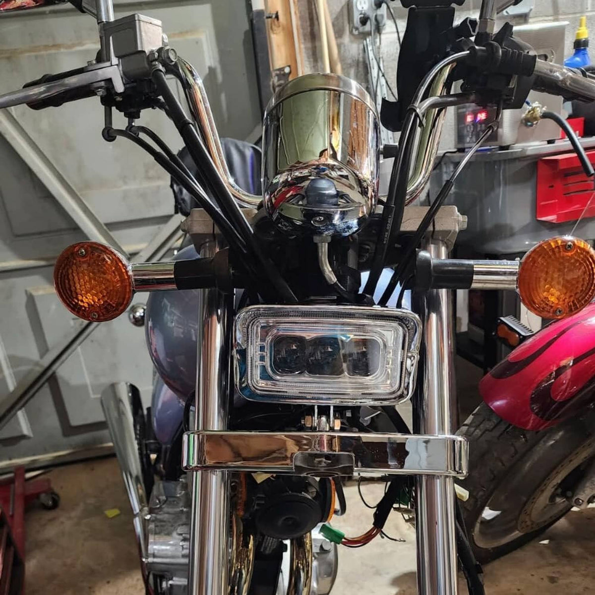Squared chrome LED headlight with amber turn signals on a motorcycle front