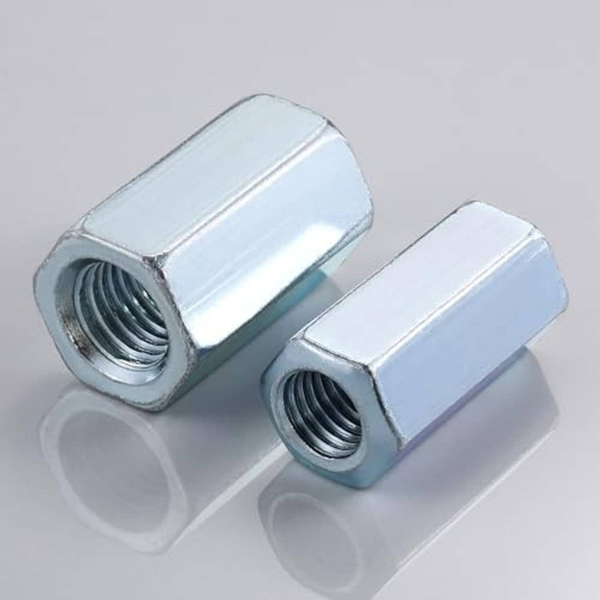 Two zinc-plated extended hex coupling nuts for 1/4-20 threaded rod, angled view
