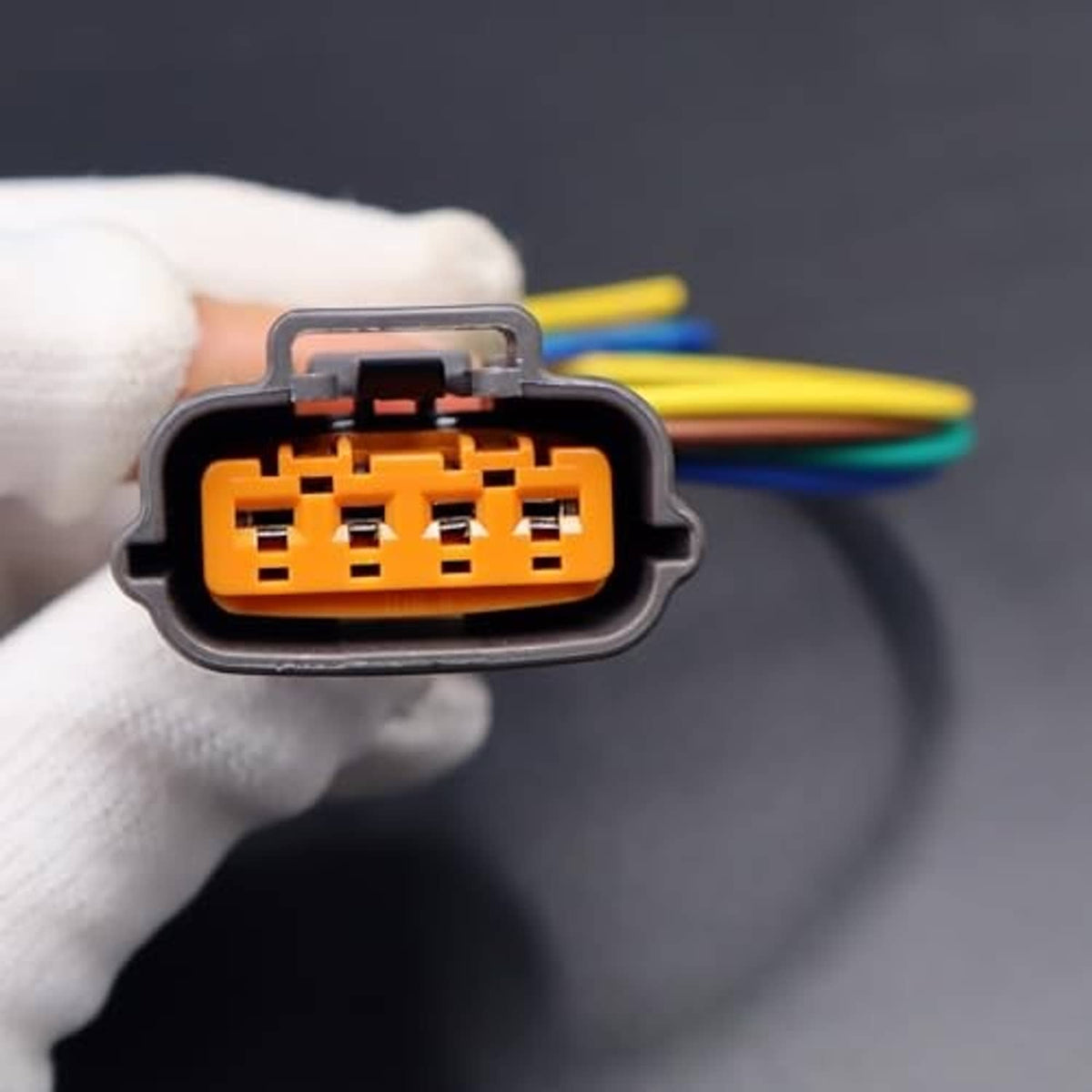Close-up of gray 4-pin TPS connector with orange pin block and multicolor wires