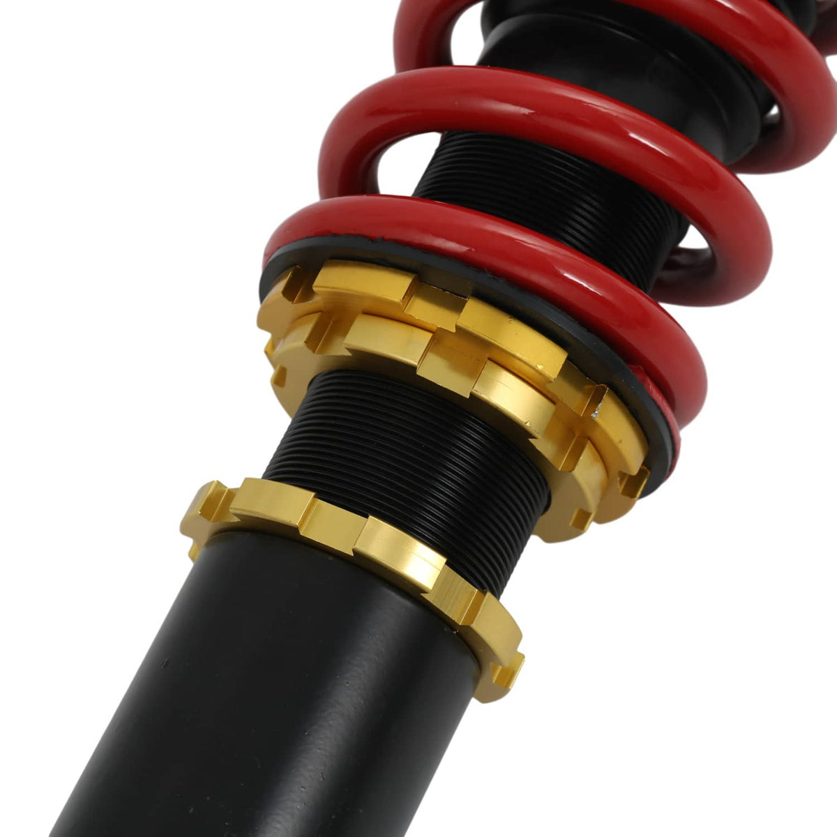 Detail of coilover strut adjuster collars and red coil spring on black shock body