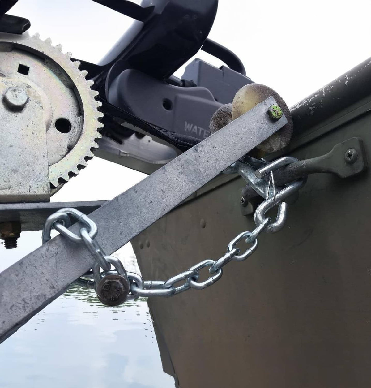Steel safety chain hooked to trailer frame on towing bar