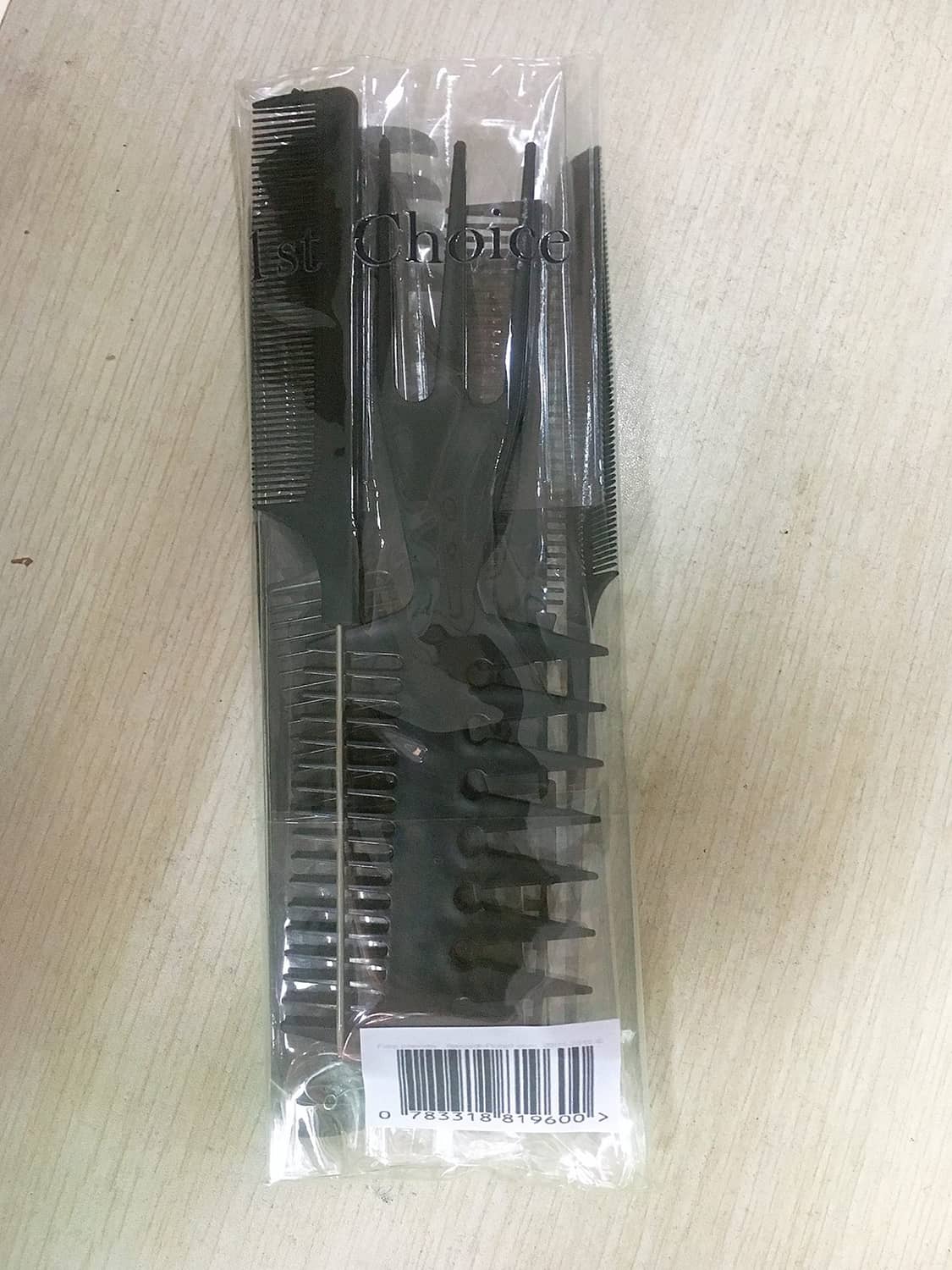 Black hair combs in a clear plastic sleeve with barcode label