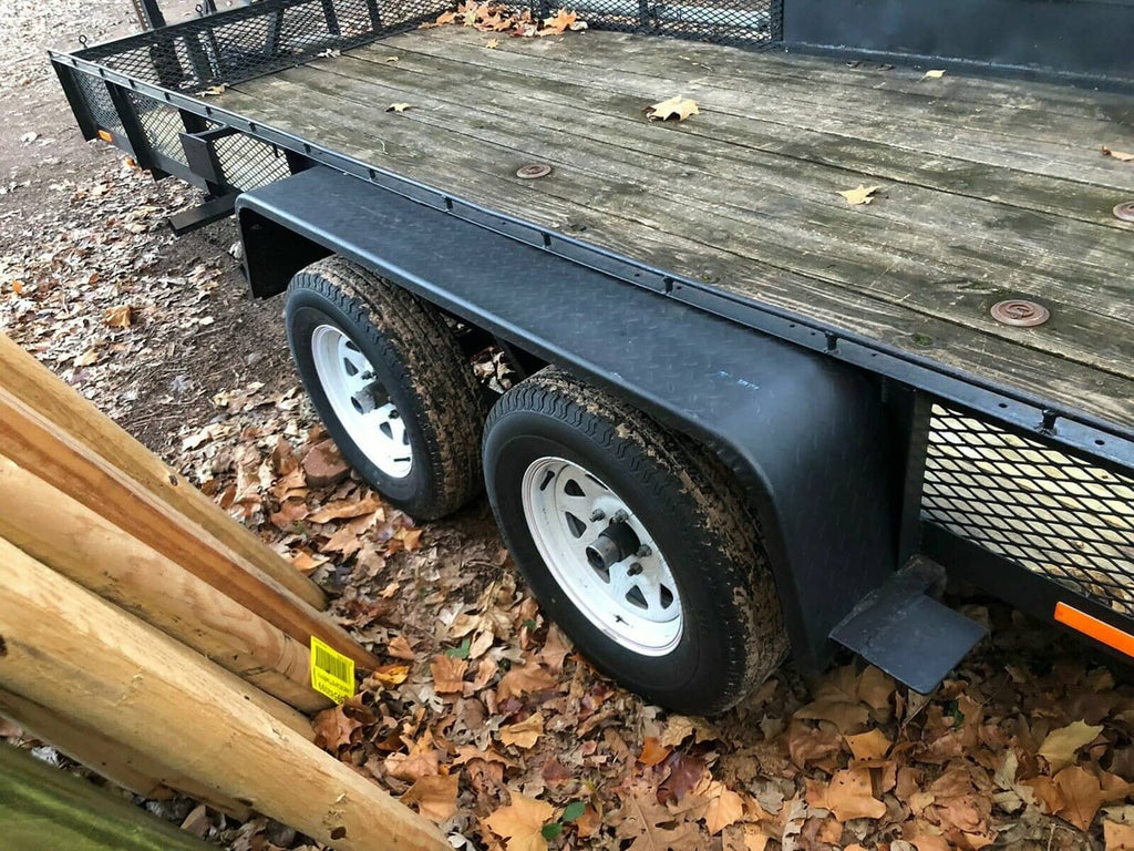 Mounted steel diamond tread trailer fenders with white wheels on a tandem axle trailer