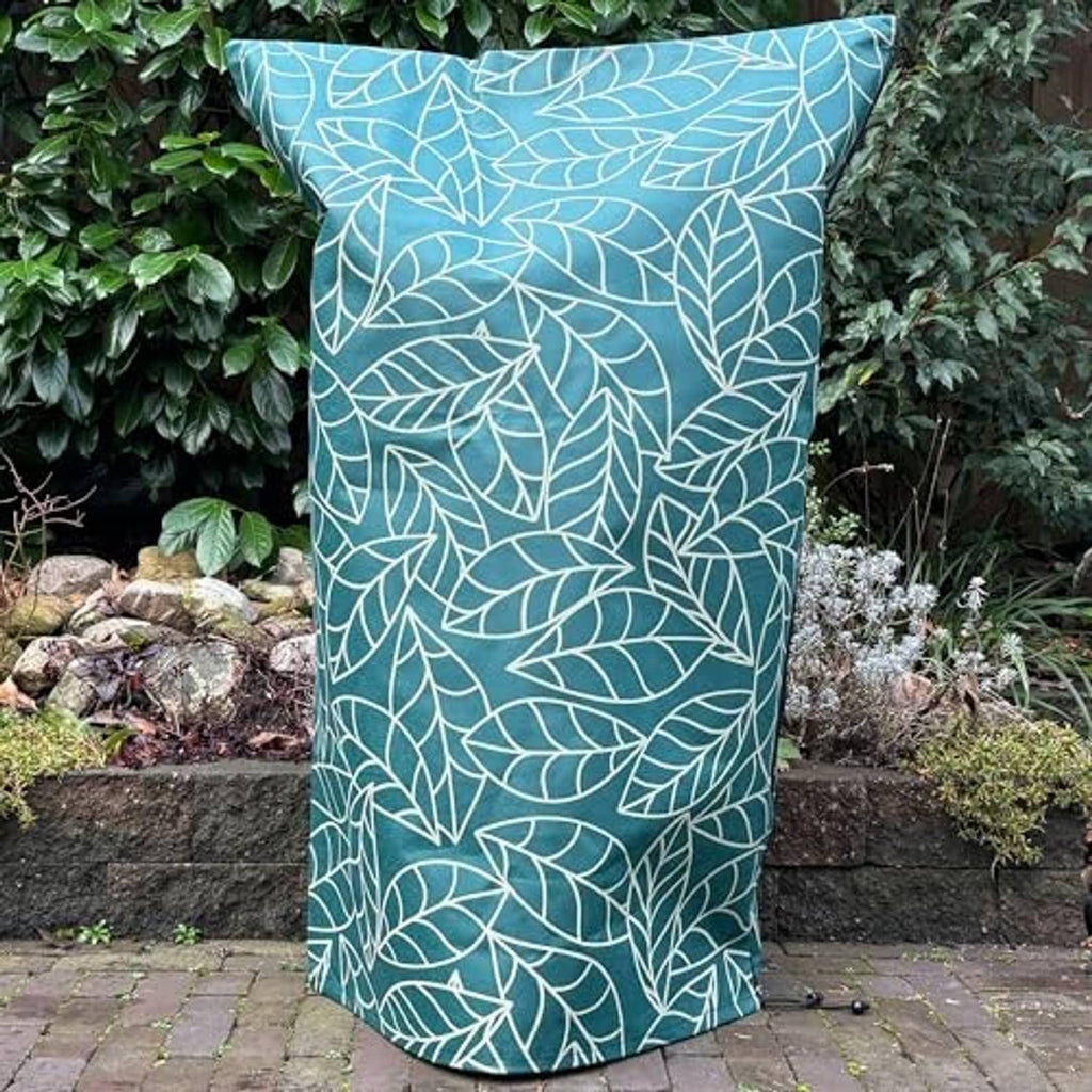 Green plant frost cover with white leaf print draped over a garden plant pot