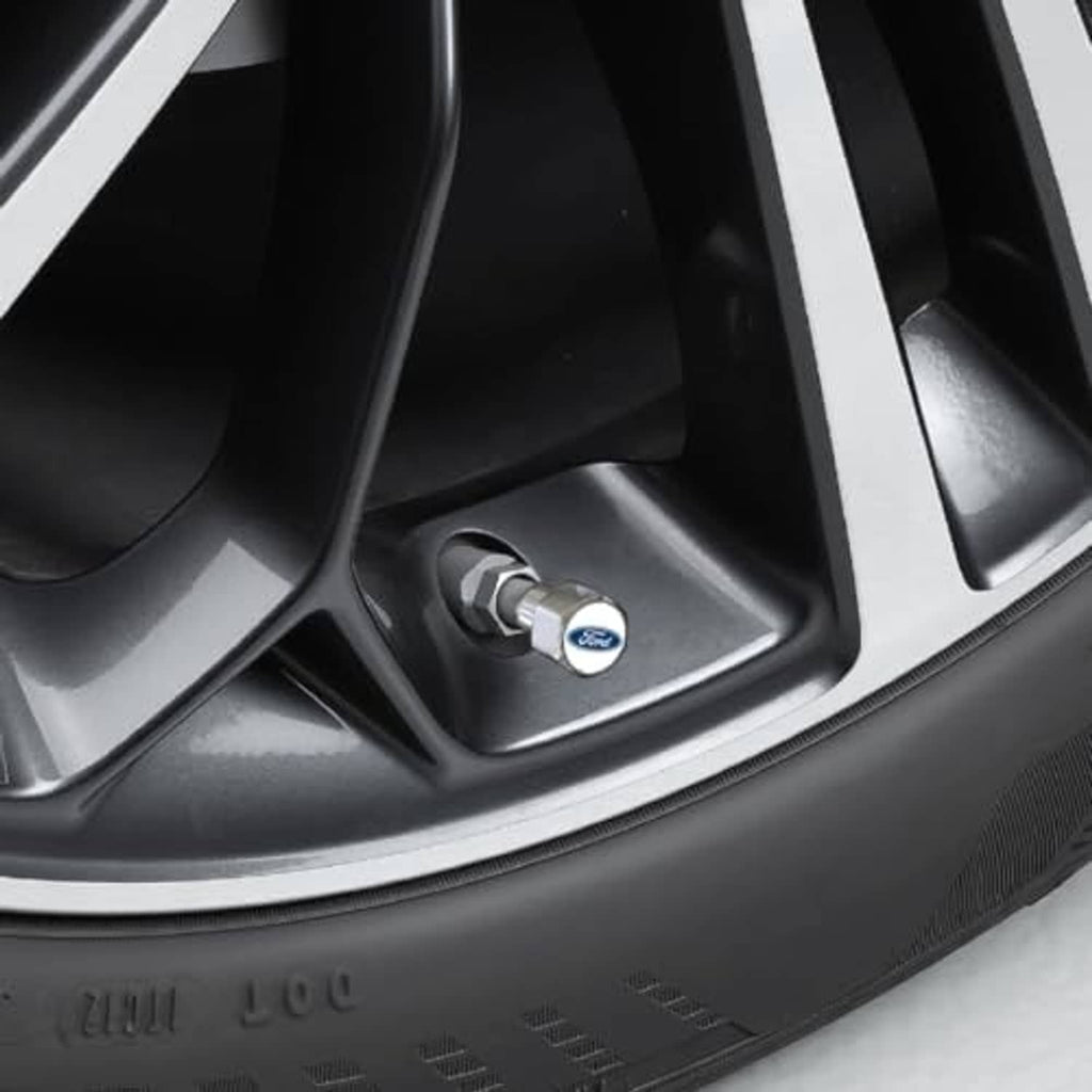 Installed chrome tire valve cap cover with blue Ford logo on the valve stem