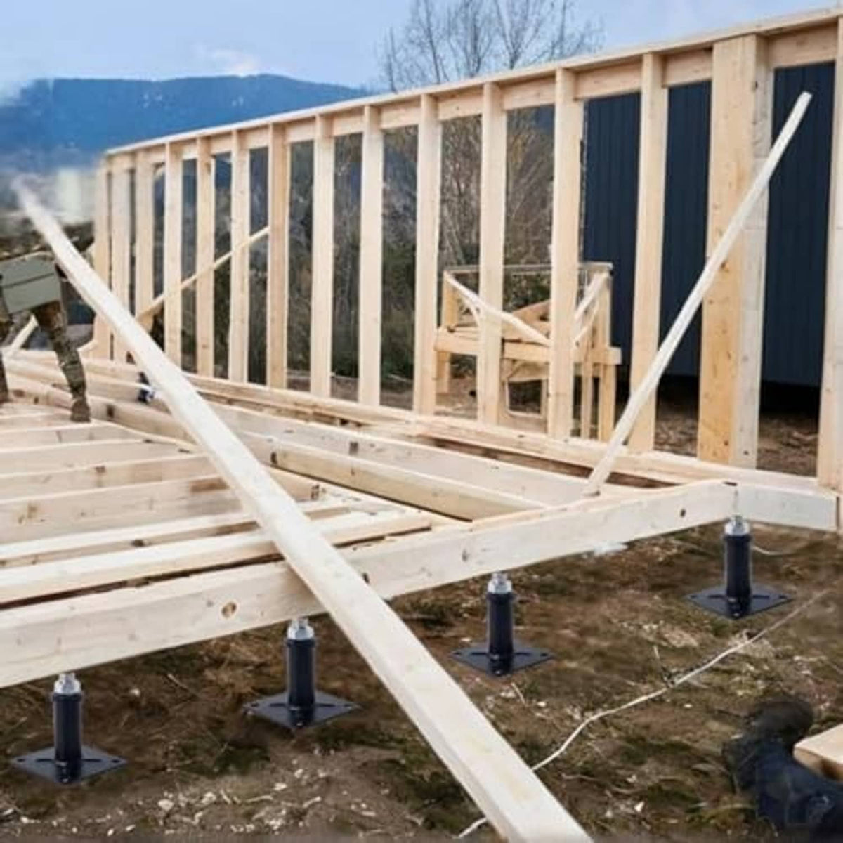 Outdoor deck frame supported by multiple black jack lift posts with square bases