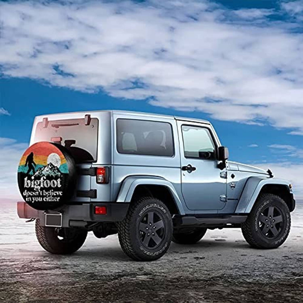 Black spare tire cover with Bigfoot print on the back of an SUV-style RV