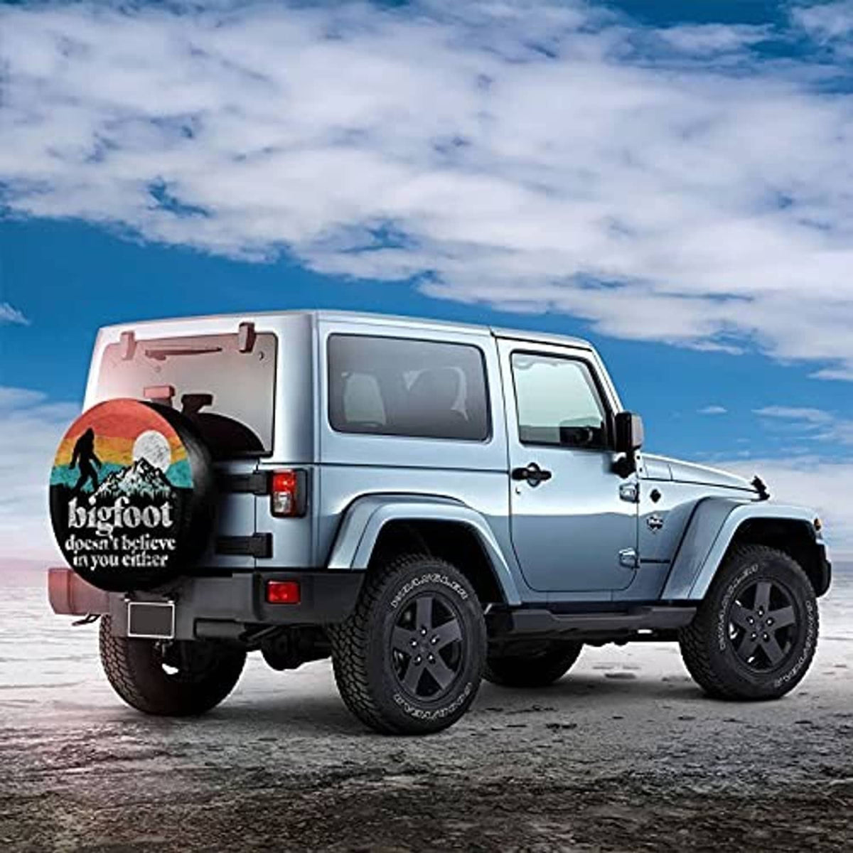 Black spare tire cover with Bigfoot print on the back of an SUV-style RV