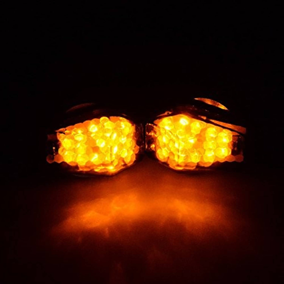 Two amber LED turn signal indicators glowing with smoke lenses and black housings