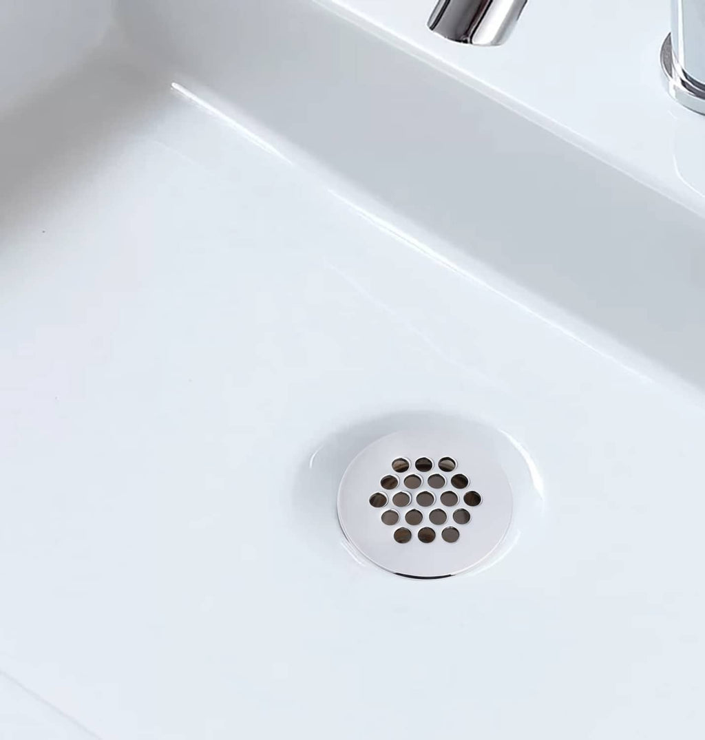 Round chrome sink drain strainer with grid holes in a bathroom basin