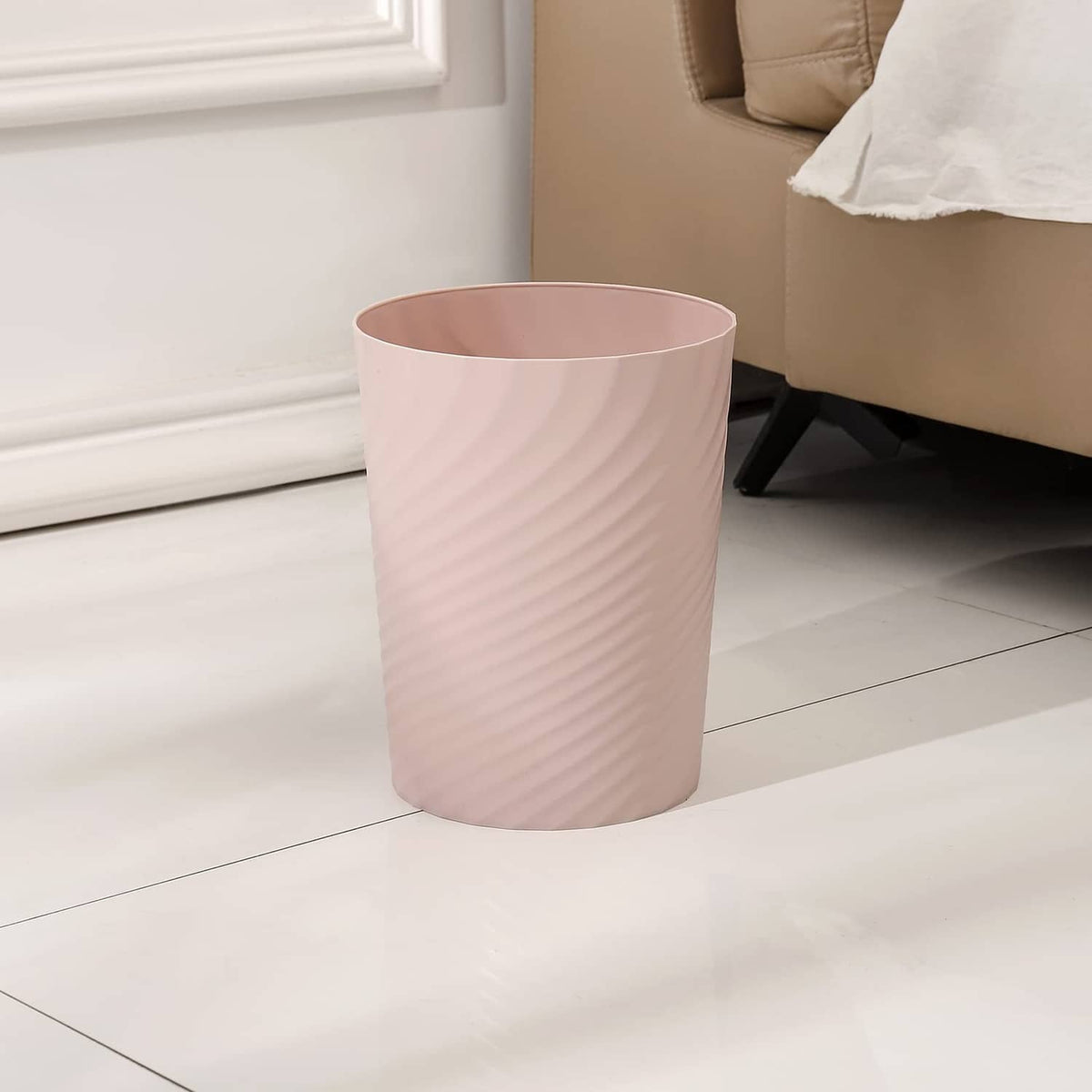 Light pink plastic waste bin with ribbed texture and open rim