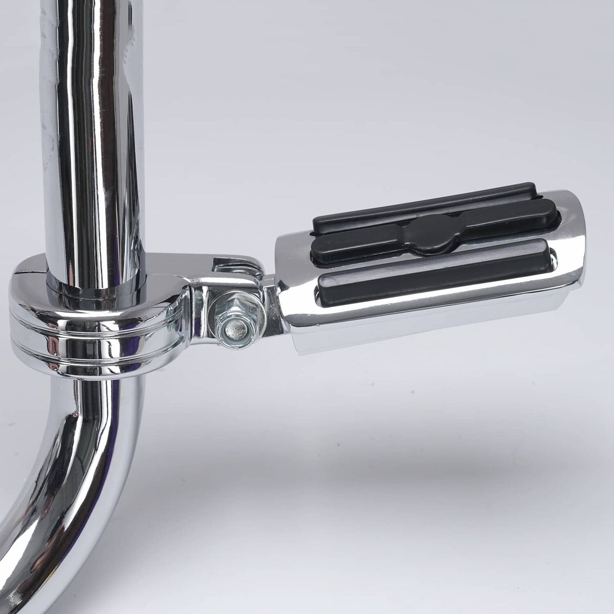 Close-up of chrome footpeg bracket with black rubber tread pad and mounting bolt