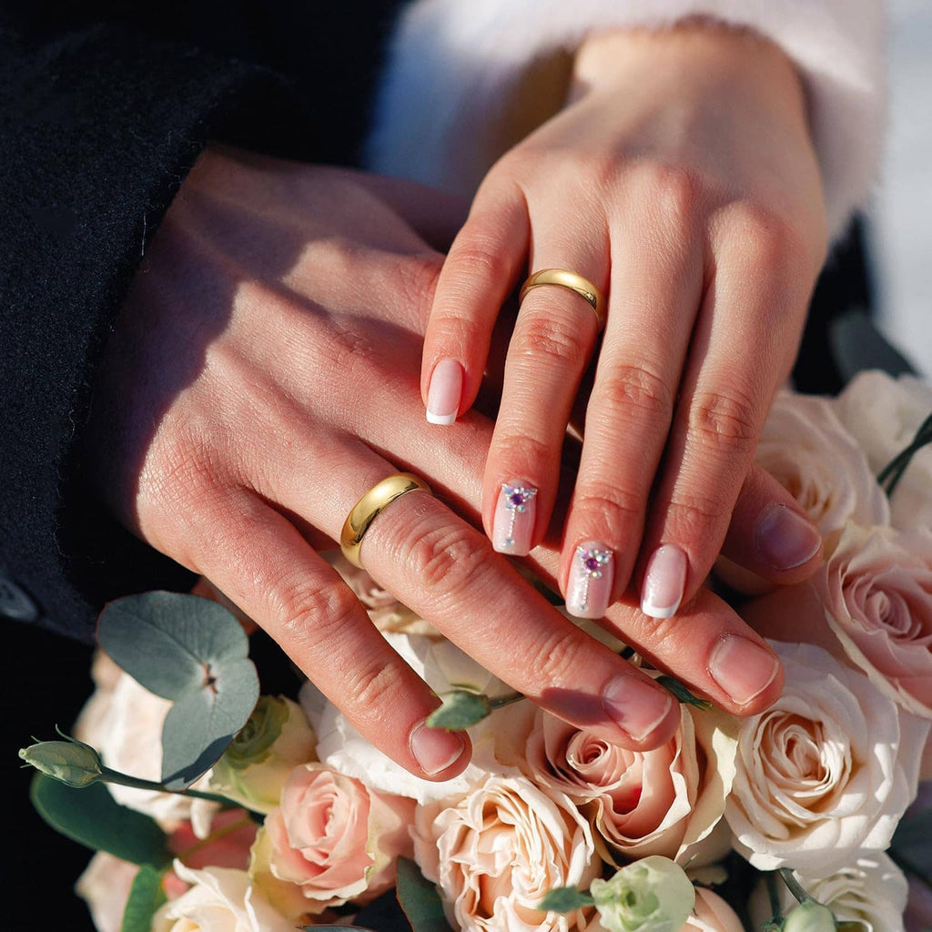 Gold plated tungsten carbide rings on hands, glossy bands