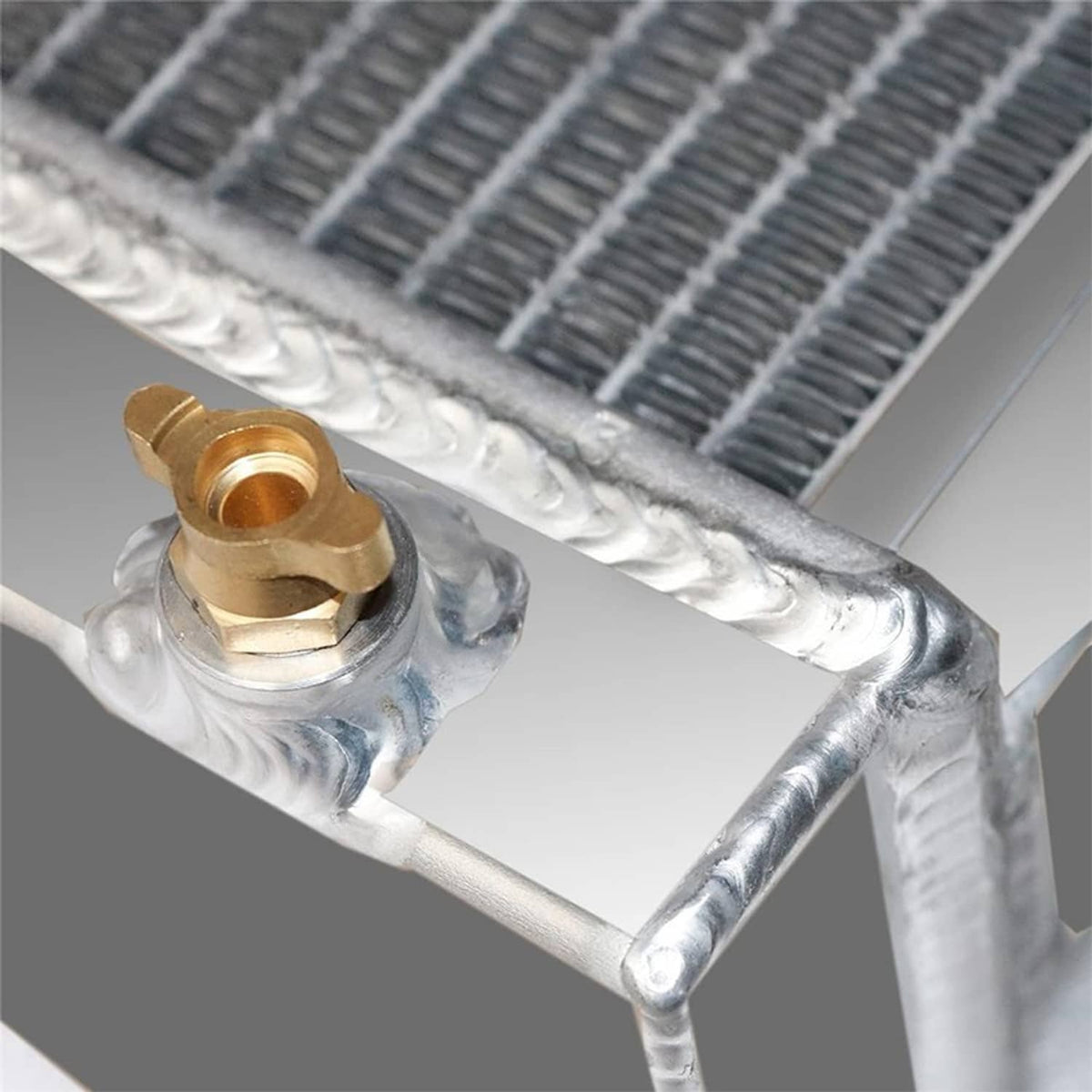 4-row radiator header with brass petcock fitting on silver aluminum tube