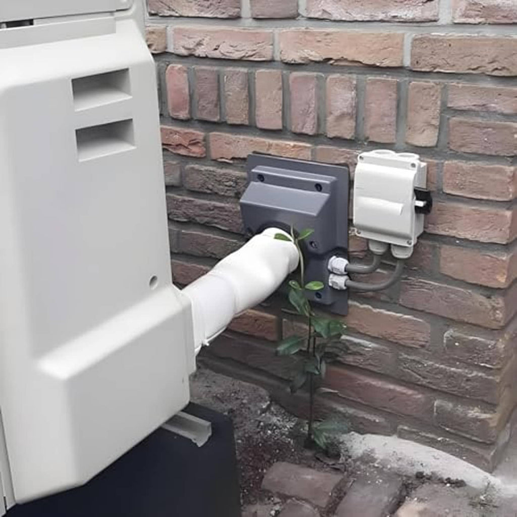 Installed gray wall line-set cover kit with black connector port on brick wall