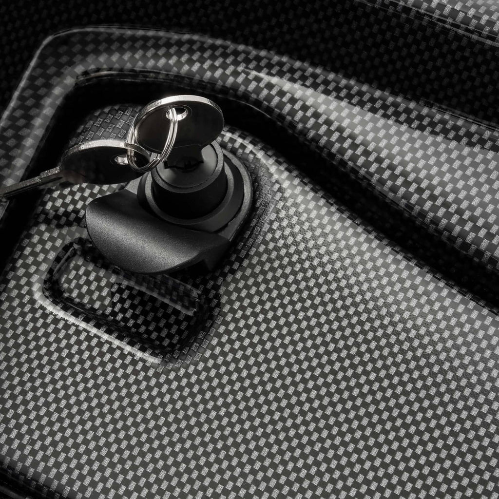 Close-up of carbon-fiber style dash cover texture with ignition-style key cylinder