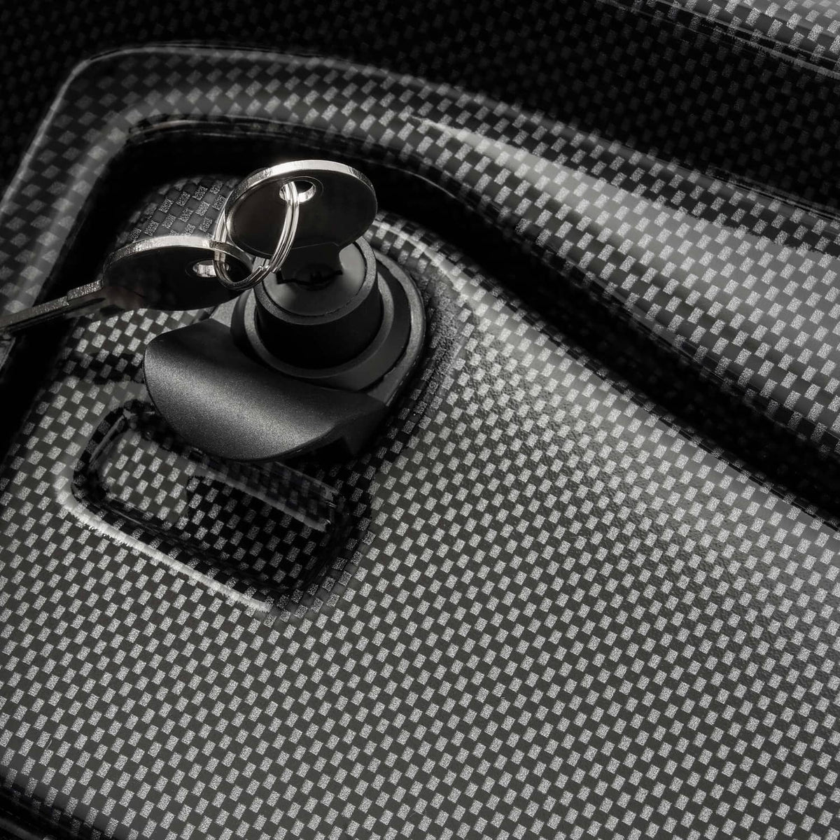 Close-up of carbon-fiber style dash cover texture with ignition-style key cylinder