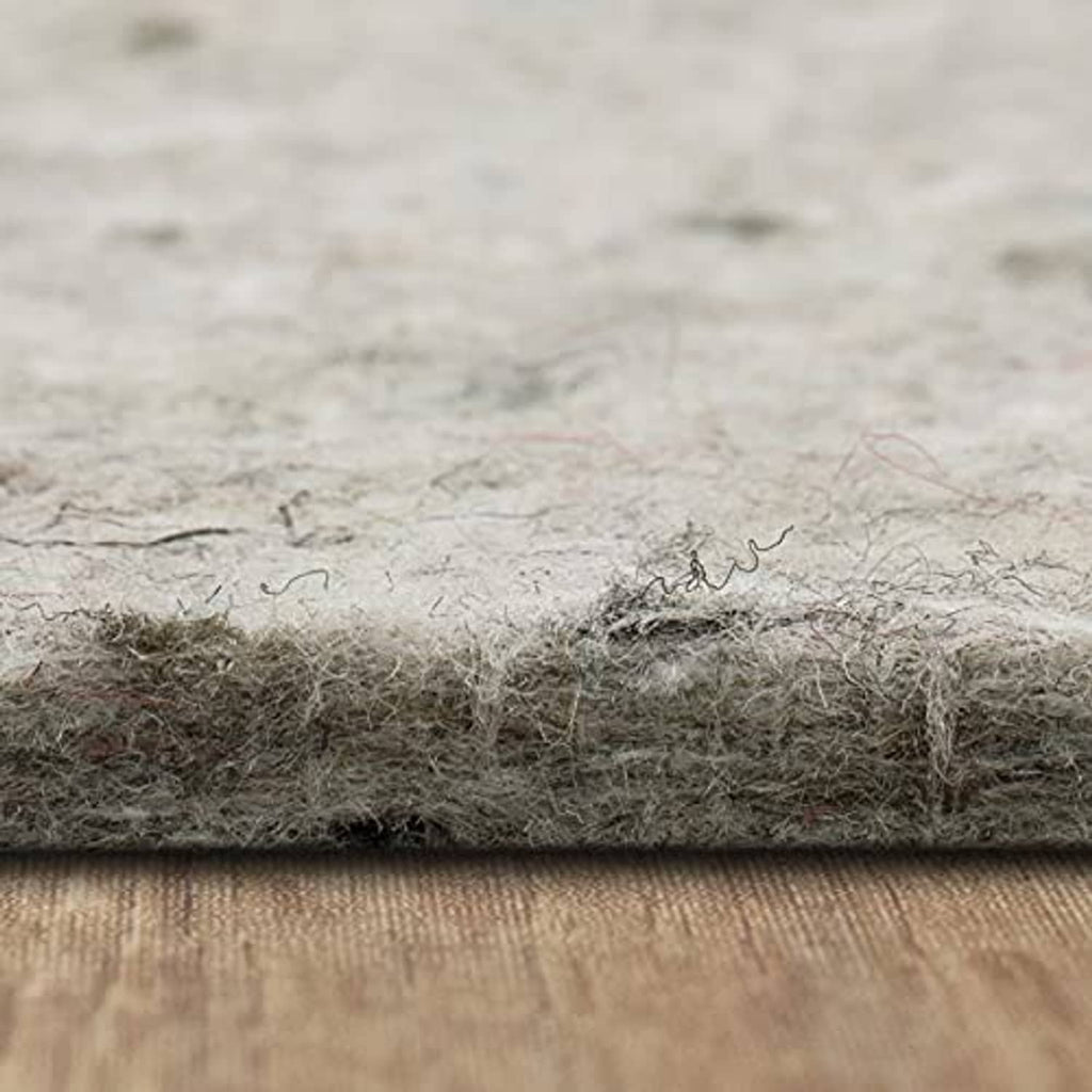 Light gray felt rug pad top with fibrous texture, cushioning layer edge