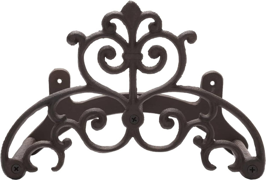 Dark metal wall-mounted garden hose hanger with ornate scroll centerpiece and side hooks.