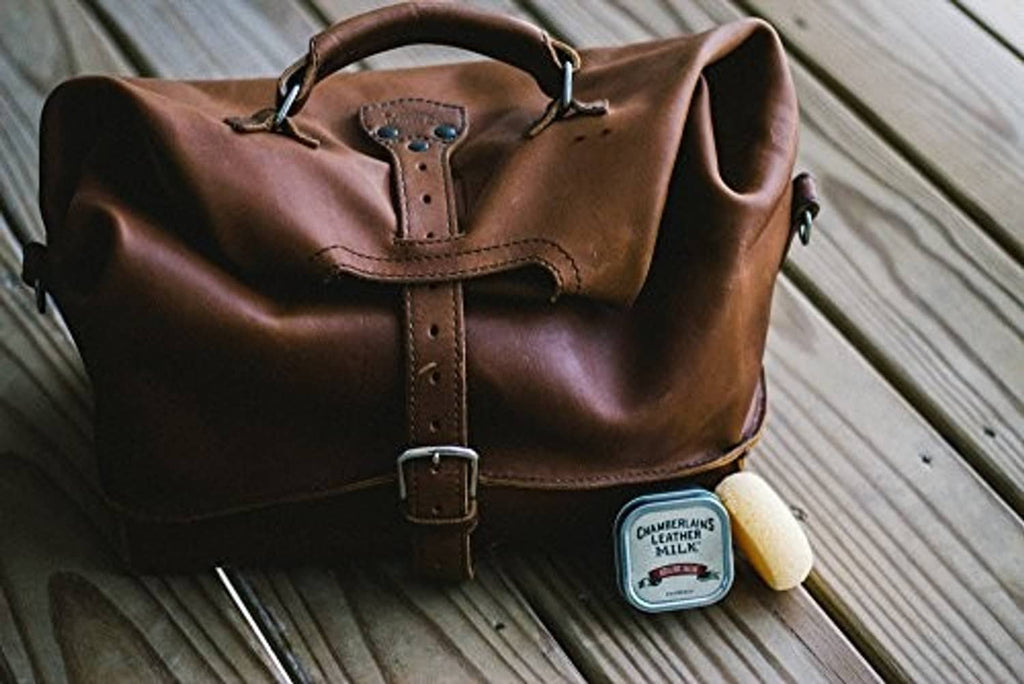 Brown leather bag with handle and Chamberlain's Leather Milk tin