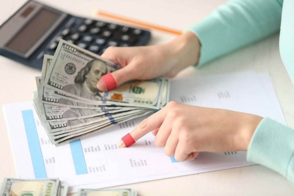 Red finger tip grips on fingers counting cash and handling papers