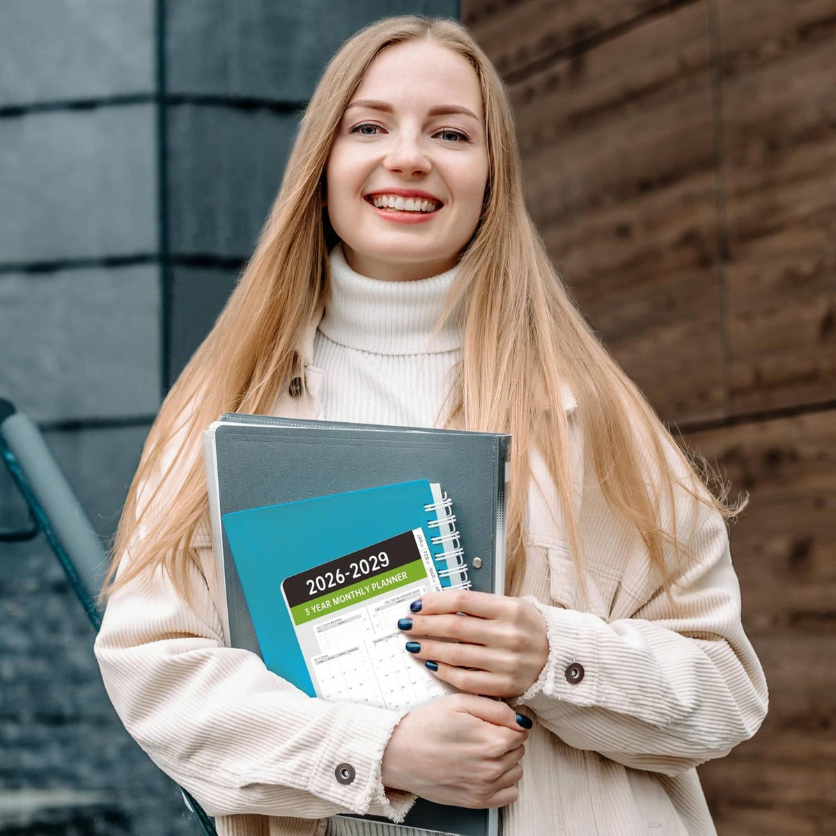 Person holding a black A6 monthly planner refill booklet with tabbed pages inside
