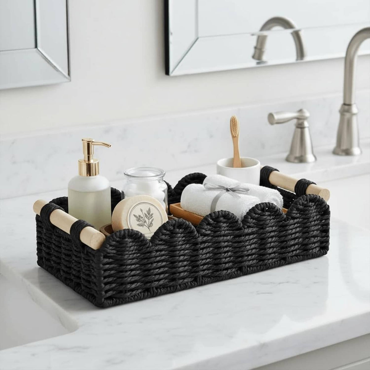 Black woven organizer basket with wood-capped handles on a bathroom countertop