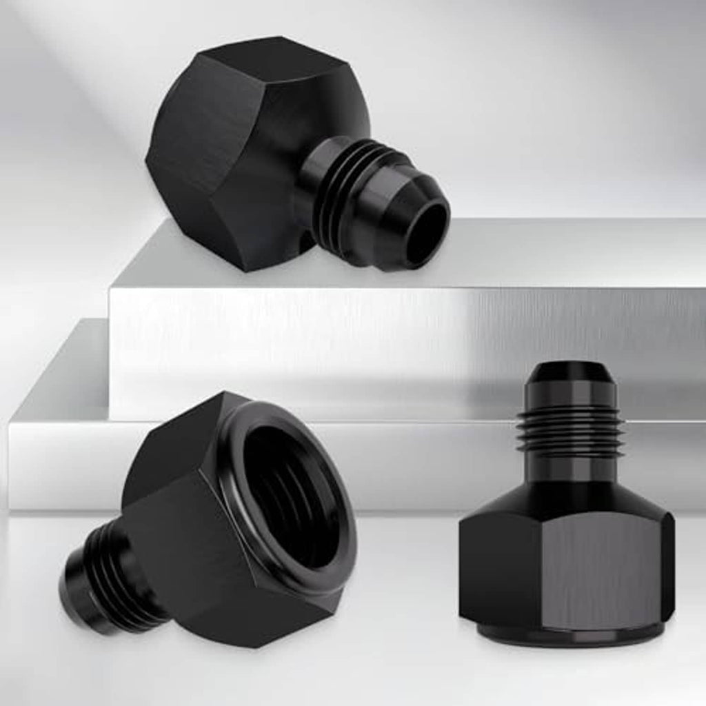 Black AN hose reducer fittings with hex bodies and threaded connections on metal surface.