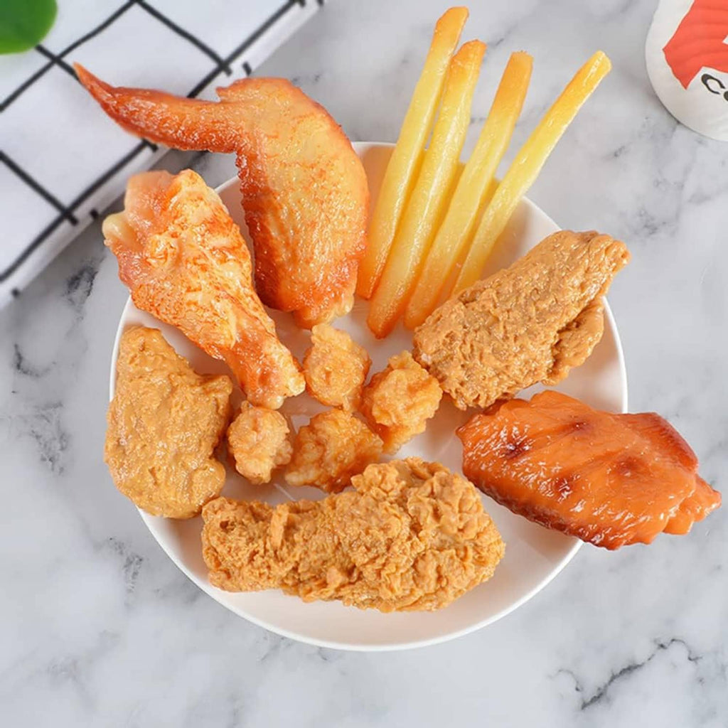 Faux fried chicken drumsticks and pieces on plate, orange-brown textured coating.