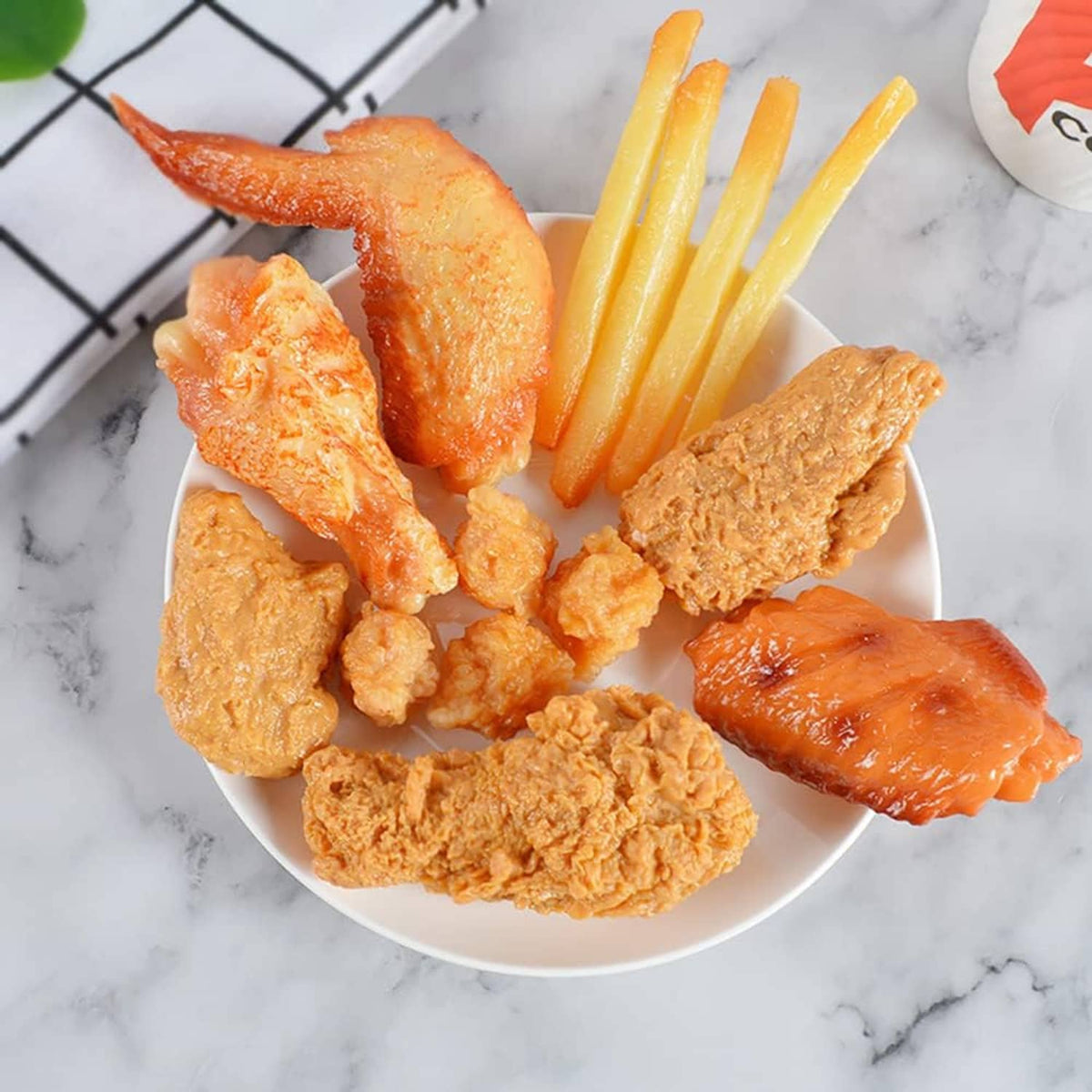 Faux fried chicken drumsticks and pieces on plate, orange-brown textured coating.