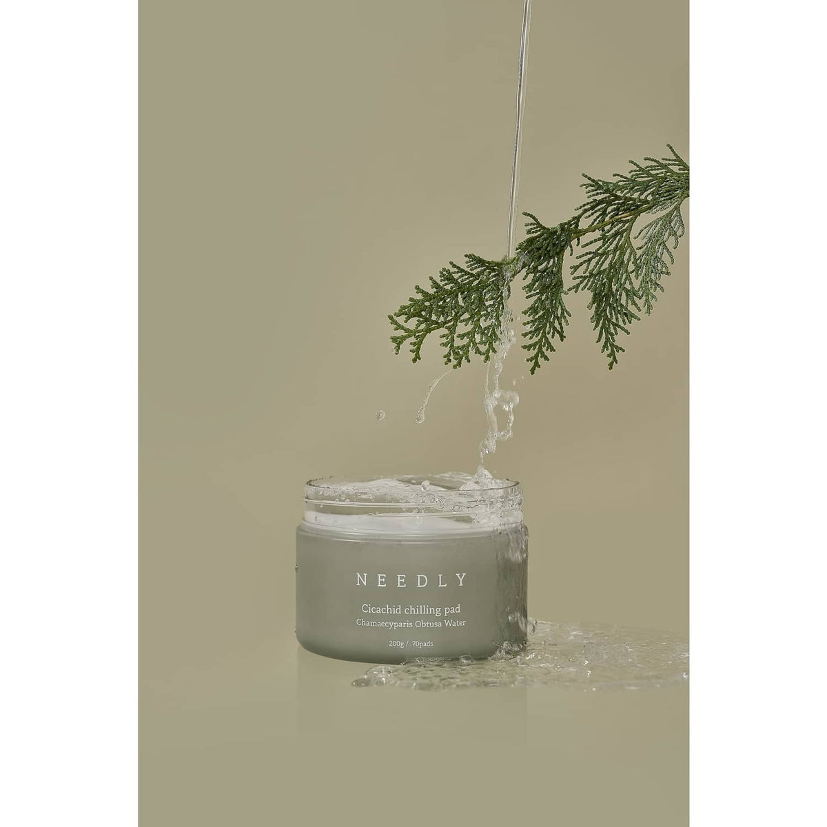 NEEDLY cleansing pad jar with water splash and green herb sprig