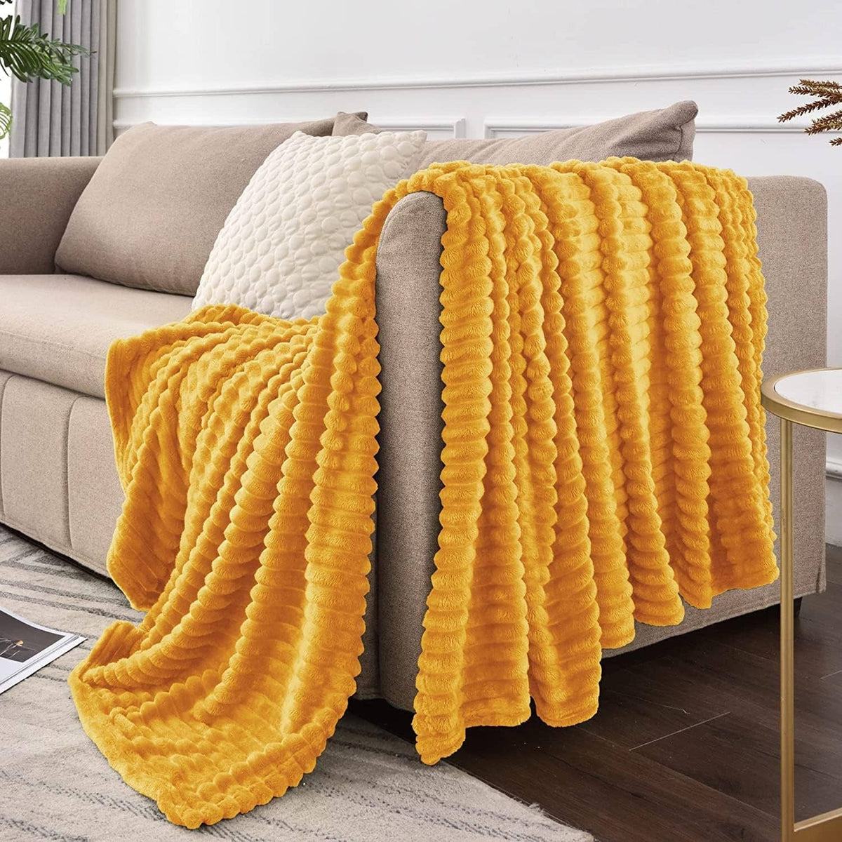 Yellow 3D ribbed jacquard fleece blanket on sofa with cascading edge