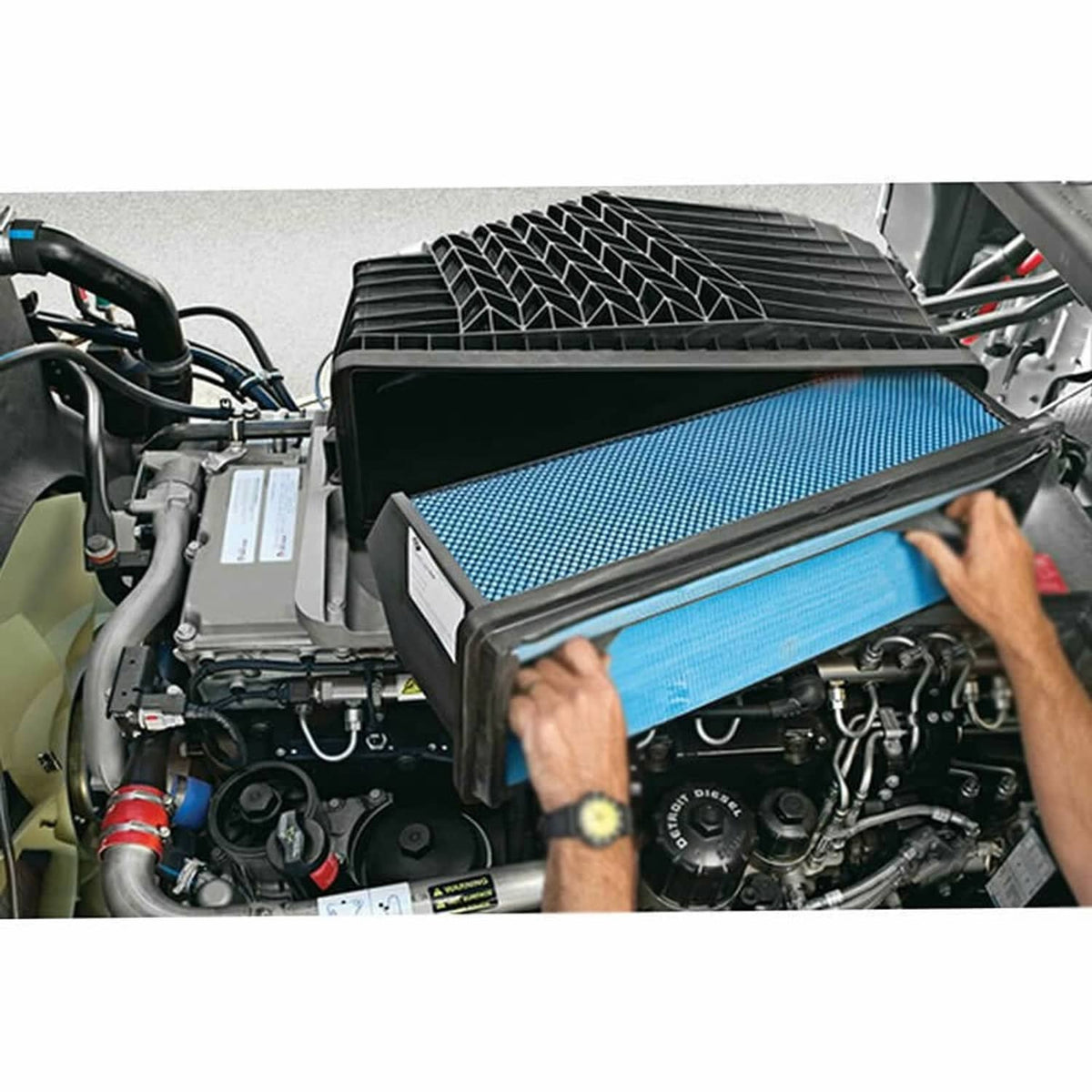 Blue mesh engine air filter with black frame being installed in engine bay