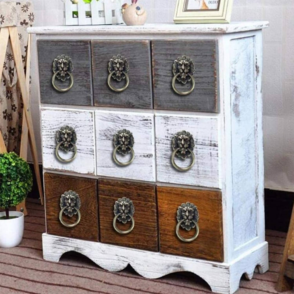 Lion head drawer pulls on a cabinet dresser with multiple bronze ring handles
