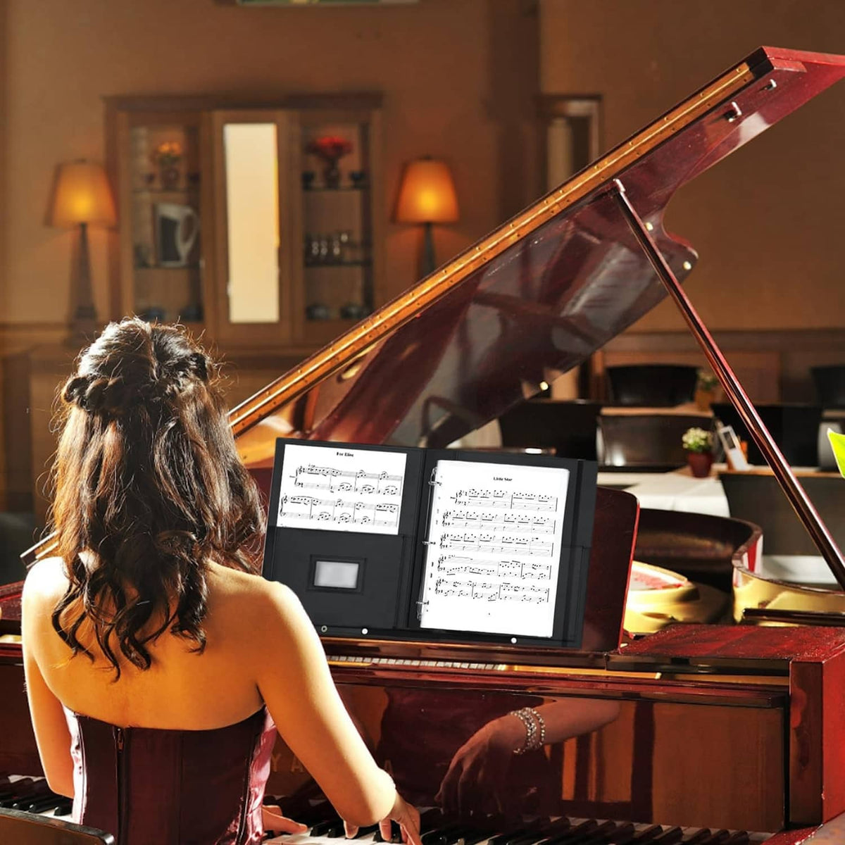 Black choir music folder propped at piano with sheet pages visible