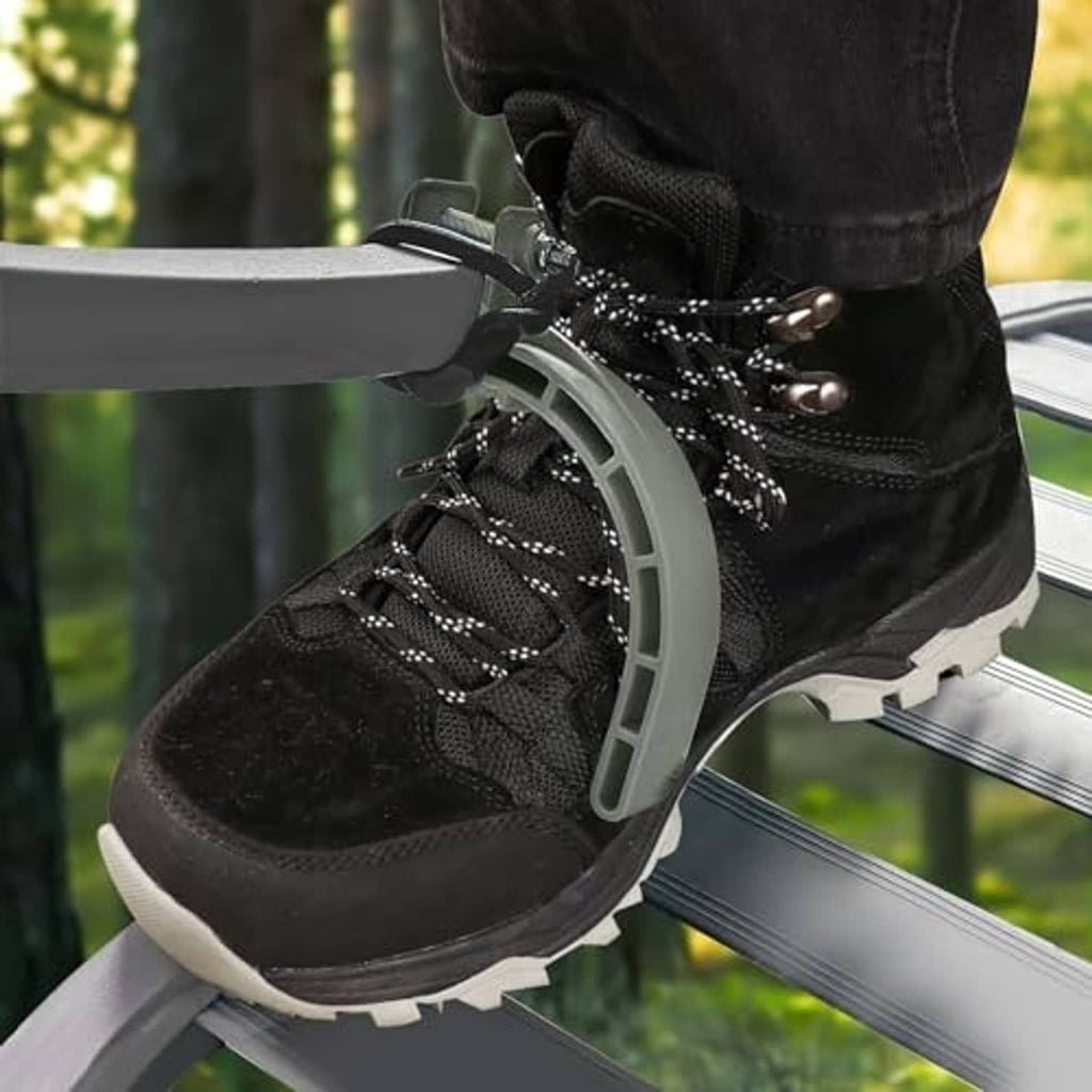Black hiking boot in gray climbing stirrup connected to tree stand rail