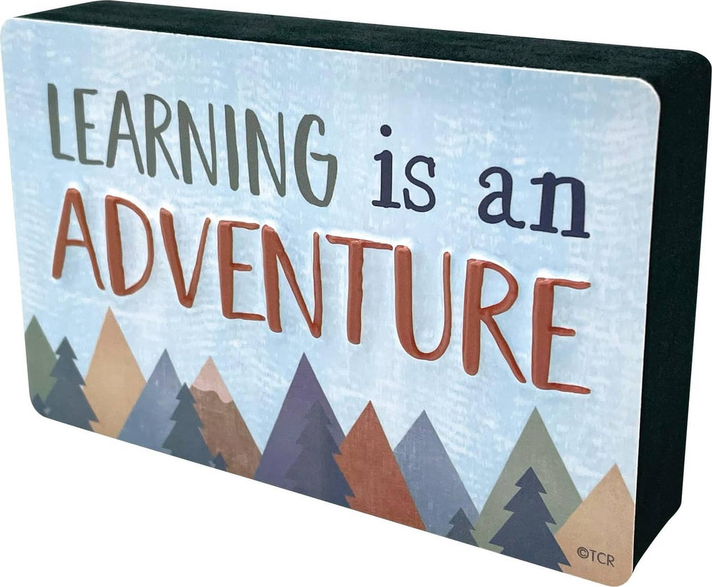 Magnetic whiteboard eraser tray with “Learning is an Adventure” mountain artwork