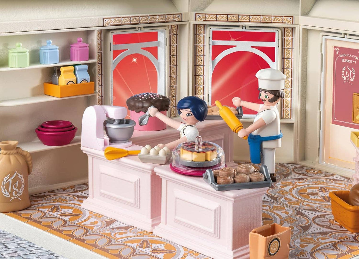French bakery counter interior with cookware, cakes, trays, and two chef figures