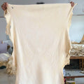 Off-white chamois leather cleaning cloth draped open, ragged edges