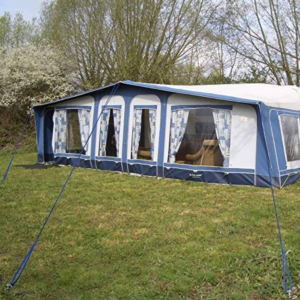 Ground anchors holding a tent guyline system on grass outdoors