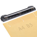 3-hole ring binder punch with built-in ruler and metal punch head on paper