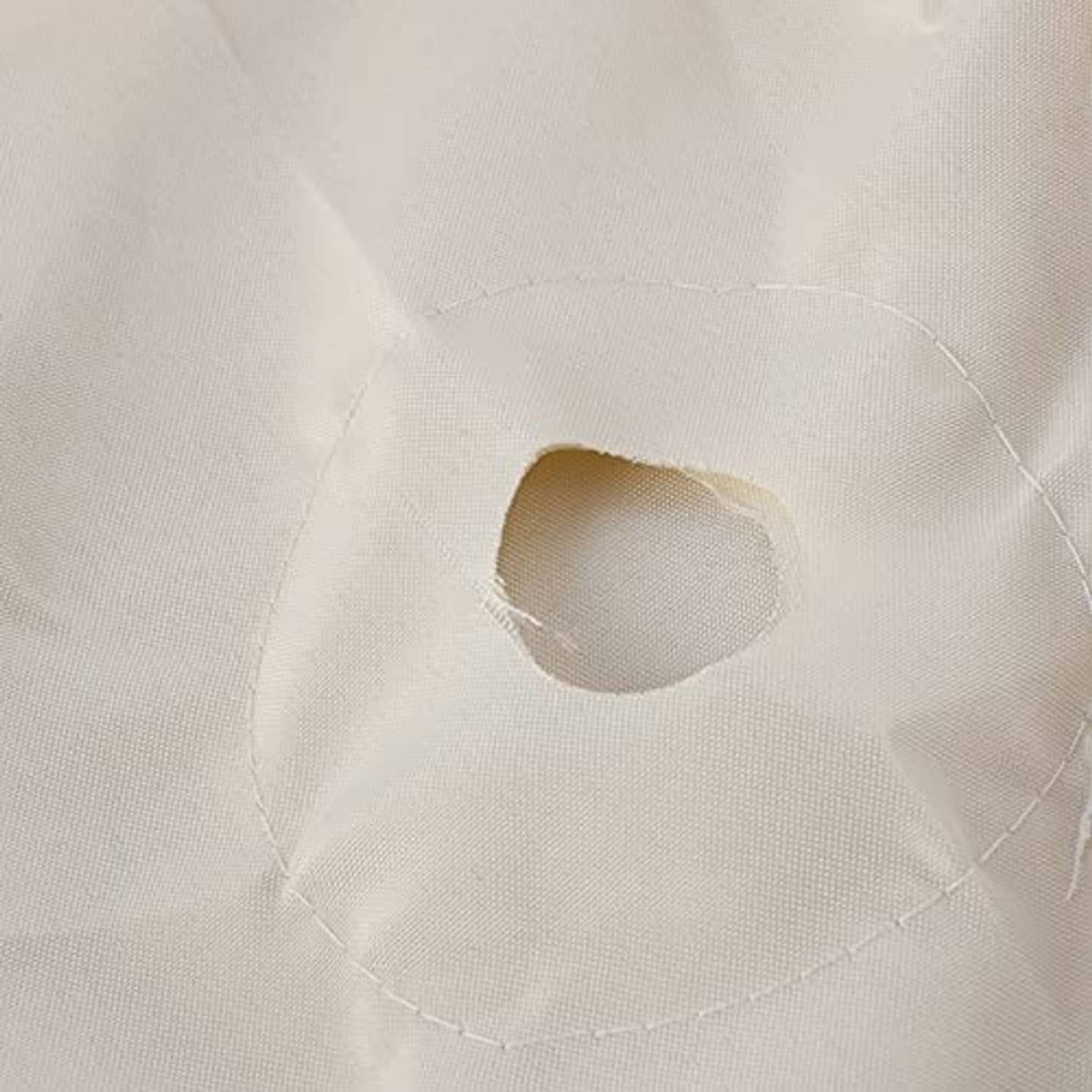 Close-up of light cream umbrella canopy underside with vent opening and stitching