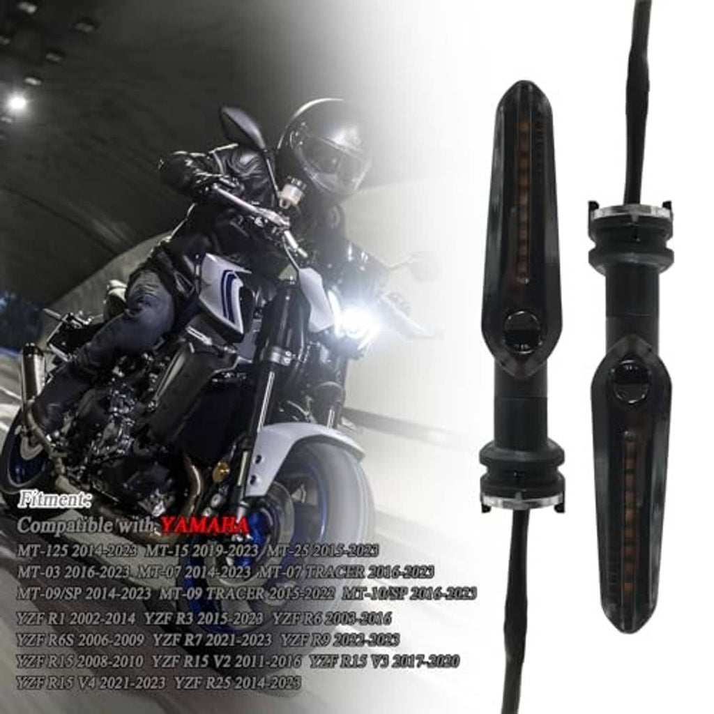 Amber-lit motorcycle LED turn signal arrows on black smoked housings