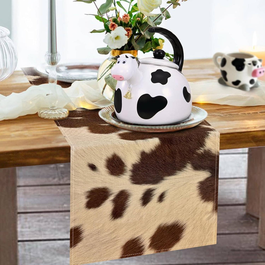Cow print table runner on wooden table with brown and white patch pattern