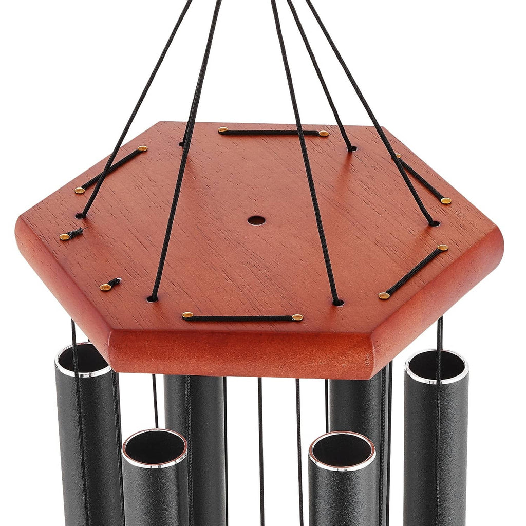 Outdoor wind chime close-up: reddish top plate, black cords, and black tubes