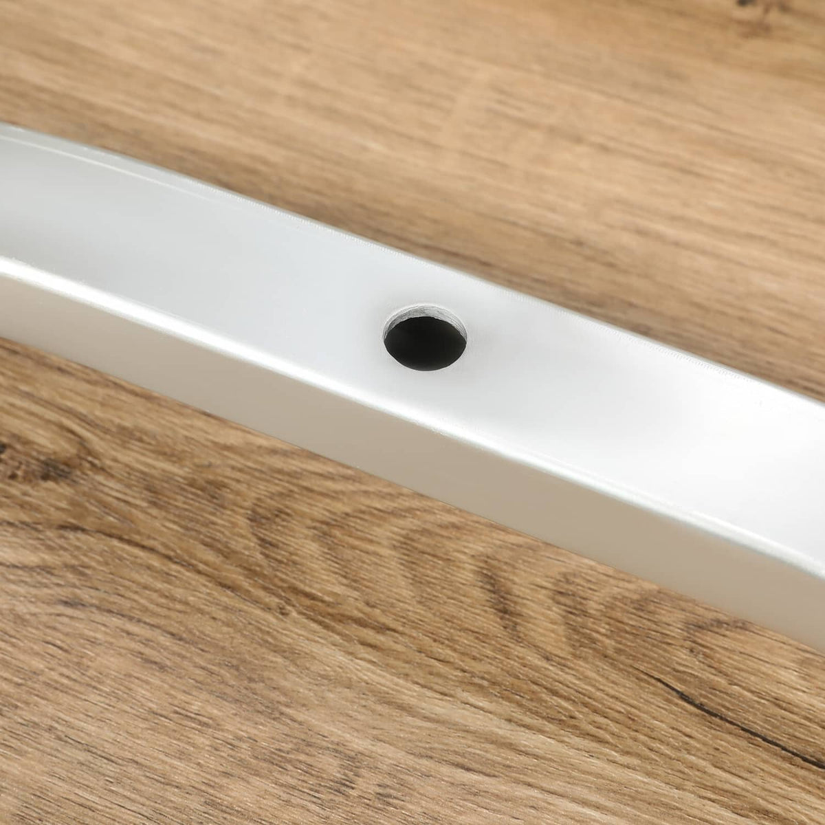Silver ski tie-down bar with black mounting hole cutout