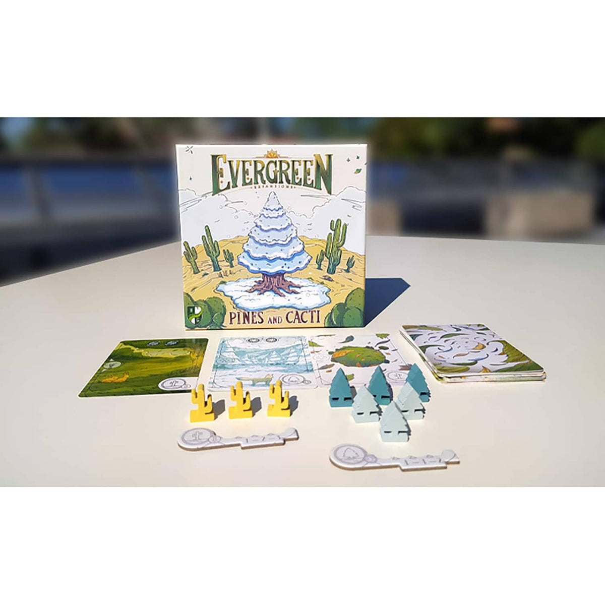 Evergreen Pines and Cacti expansion box with scattered terrain cards and cactus-tree pieces