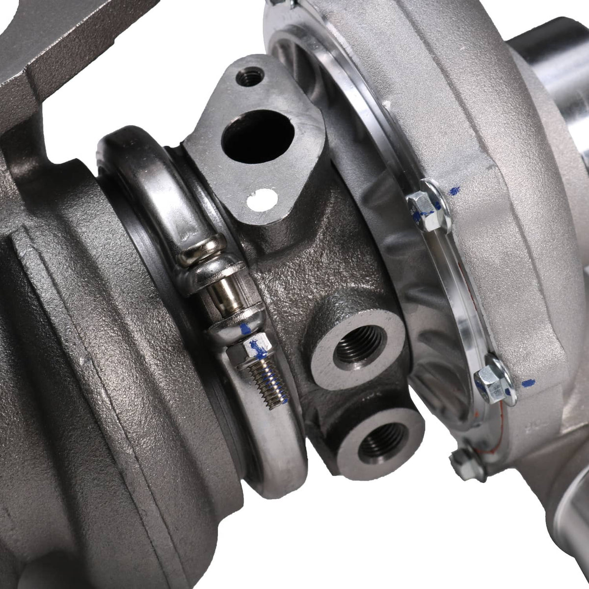Turbocharger detail view showing exhaust housing, bolts, and oil return lines