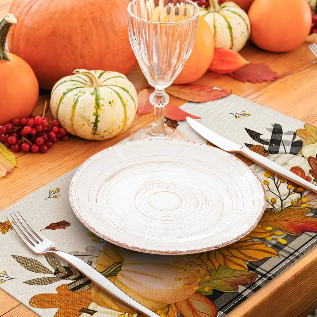 Beige placemat with fall leaves, pumpkins, and wheat motifs under tableware