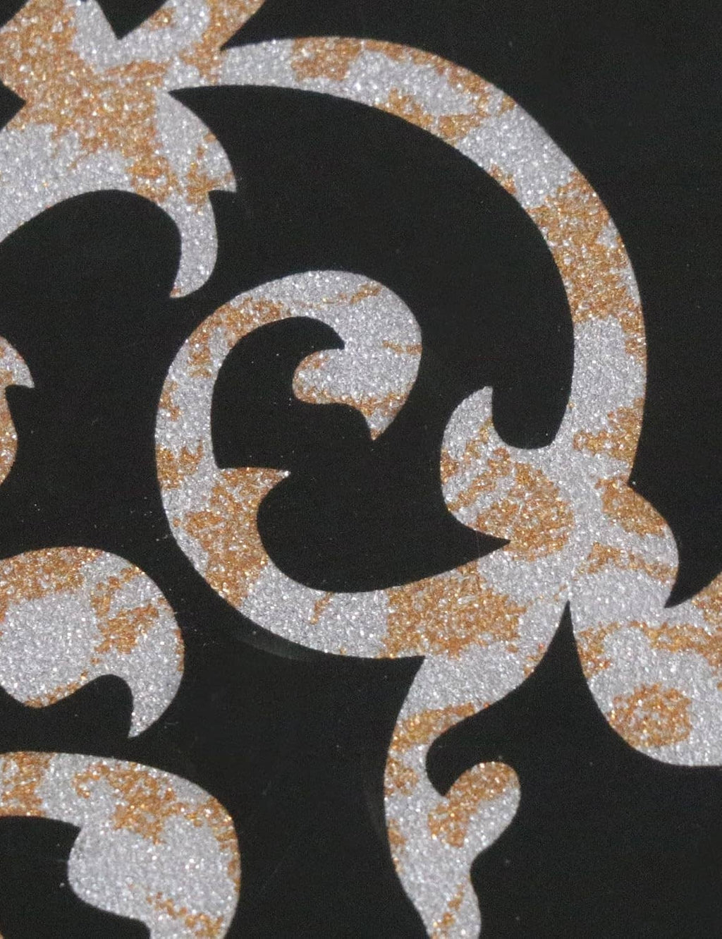 Close-up of black pickguard with glitter gold scroll-and-floral pattern